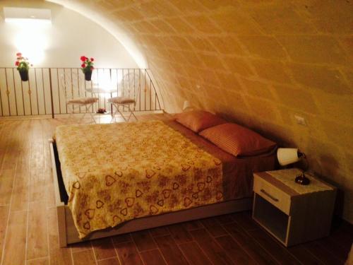 ein Schlafzimmer mit einem Bett in einer Ziegelwand in der Unterkunft Le due arcate in Matera