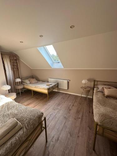 a attic bedroom with two beds and a window at Magnolina - Dom całoroczny na Mazurach in Faryny