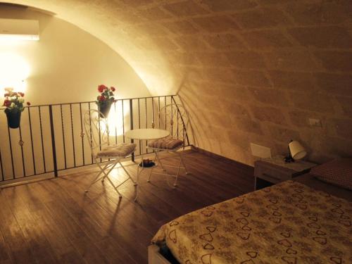 a room with a bed and a balcony with a table and chairs at Le due arcate in Matera