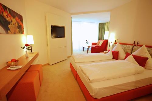 a hotel room with two beds and a couch at Parkhotel Flora am Schluchsee in Schluchsee