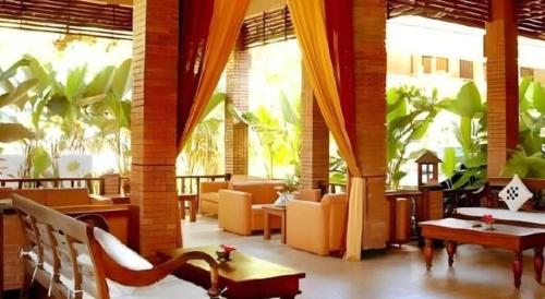 un ristorante con divani, tavoli e sedie di Nyiur Resort Hotel a Pangandaran