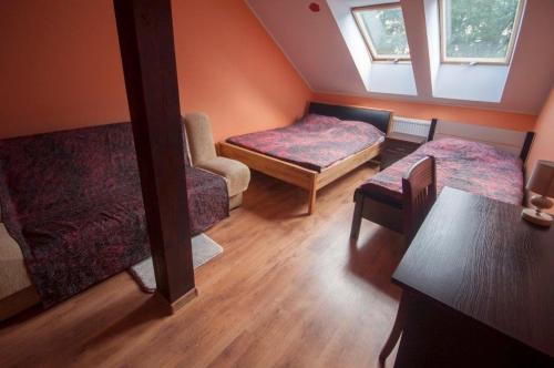 a room with two beds and a chair and a window at Pensjonat Agroturystyczny Pod Modrzewiem in Florczaki
