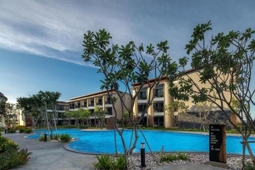 an apartment complex with a swimming pool and trees at i Tara Private in Phetchaburi