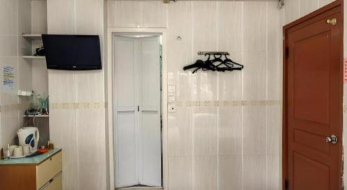 香港にあるNew Mong Kok Guest Houseのドアと壁掛けテレビのあるキッチン