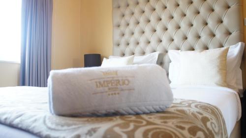 A bed or beds in a room at Hotel Império