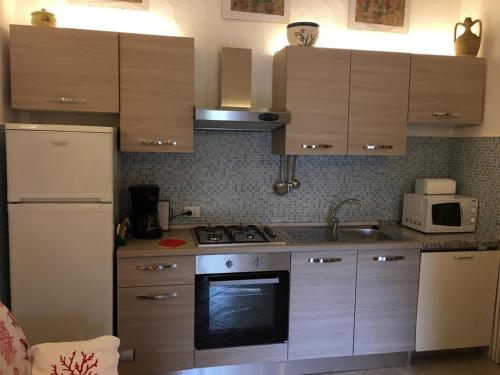 Una cocina con gabinetes de madera y un horno de estufa. en Bungalow Jasmin - 779218, en San Teodoro