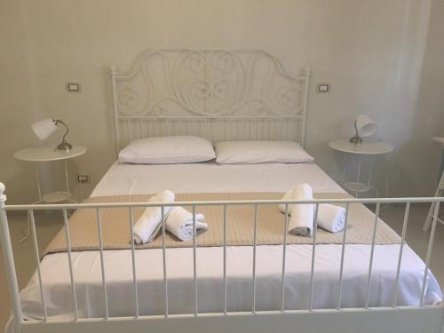 a bedroom with a bed with white sheets and white pillows at B&B La Via di Casa in San Leone