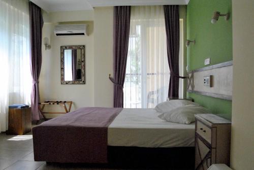 a bedroom with a bed and a large window at Benna Hotel in Antalya