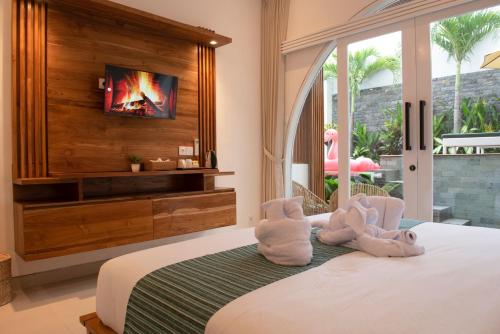 a bedroom with two stuffed animals sitting on a bed at Jasmine River Guest House in Canggu