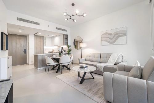 a living room with a couch and a table at Marina Horizon by LIV High Floor 1BR, For 5 Guests, Dual Gyms & Marina View in Dubai