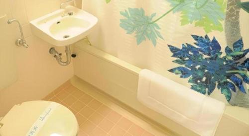 a bathroom with a toilet and a sink at Hotel Thida No Sato in Miyako Island