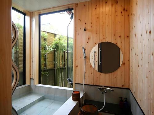 a bathroom with a shower and a mirror on the wall at Suigetsurou Hotel in Takaoka