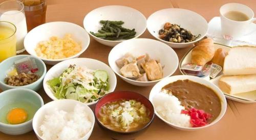 富山市にあるHotel Park Inn Toyamaのさまざまな種類の食べ物が入ったボウルが置かれたテーブル