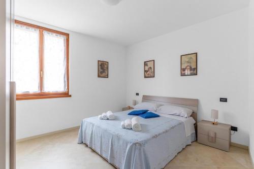 a white bedroom with a bed with towels on it at Casa della Regina, near Lake Garda in Montichiari