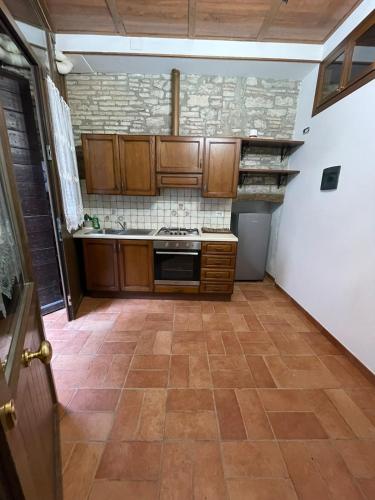 a kitchen with wooden cabinets and a tile floor at Appartamento Barone in Gubbio