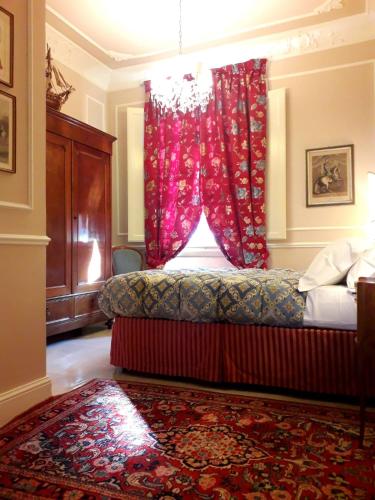 Un dormitorio con una cama con una cortina roja. en Casa Alessandro Firenze, en Florencia