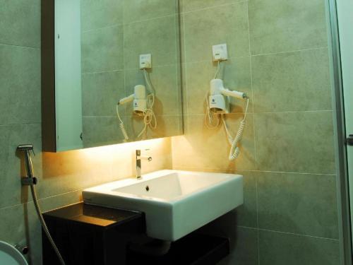 a bathroom with a white sink and a mirror at LF Hotel Tapah in Kampar