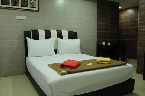 a large white bed with two towels on it at Serdang Business Hotel in Kuala Lumpur