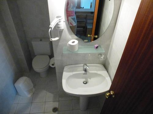 a bathroom with a sink and a toilet and a mirror at Samaria in Agia Roumeli