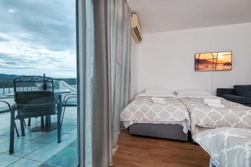 a bedroom with a bed and a balcony at Hotel Apartments More in Neum