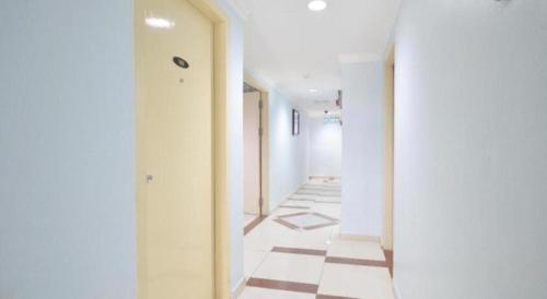 a hallway with white walls and a tile floor at OYO 969 Hotel Pantai View in Labuan
