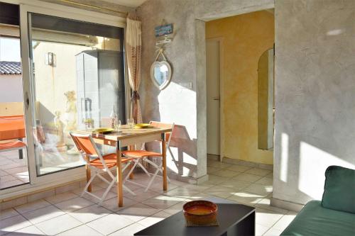 a living room with a table and chairs and a window at Appartement 3 pièces 6 couchages LEUCATE NATURISME PL010-049 in Port Leucate