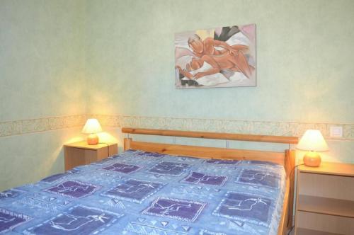 a bedroom with a bed with a blue quilt on it at Appartement 3 pièces 6 couchages LEUCATE NATURISME PL010-049 in Port Leucate