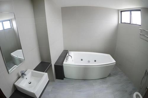 a white bathroom with a tub and a sink at Star-Well hotel in Kuala Lipis