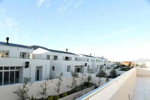 an exterior view of a white building with plants at Spatalla Holiday Homes in Kleinmond