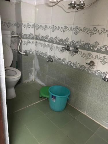 a bathroom with a toilet and a bucket in it at Krishna home stay in Tārna