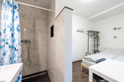 a bathroom with a shower and a bed at Mount Pilatus Rooms Lucerne in Luzern