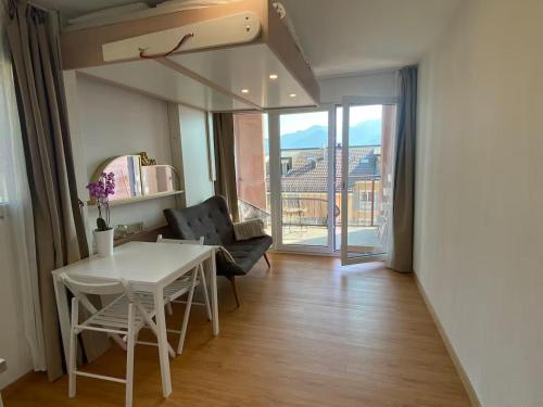 a living room with a white table and a chair at Bouveret Bay - The Balcony in Bouveret