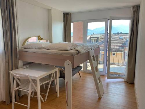 a small bed in a room with a balcony at Bouveret Bay - The Balcony in Bouveret