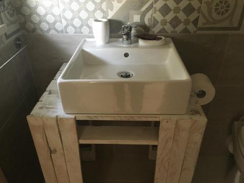 a white sink on a wooden stand in a bathroom at B&B La Via di Casa in San Leone