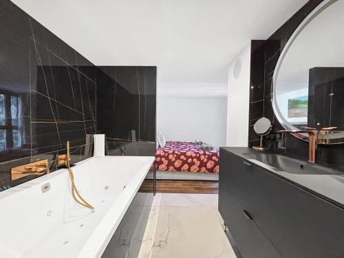a black and white bathroom with a large mirror at Grand T4 Luxe, SPA, Cheminée Baby-foot, Jardin in Aix-les-Bains