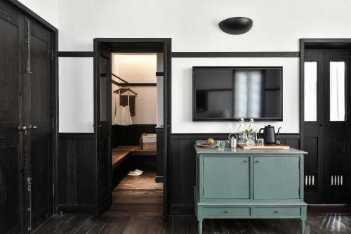 Un baño con un mueble azul y un televisor. en Humble Hall, en Gulang Yu