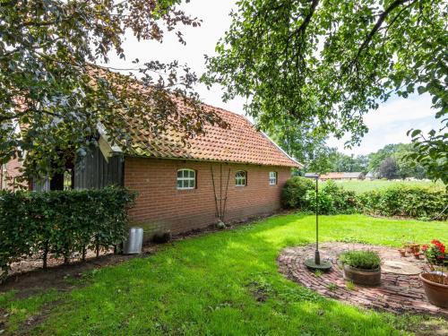 ein kleines Backsteinhaus mit einem Rasenhof in der Unterkunft Cozy Apartment in Enschede near Forest in Enschede