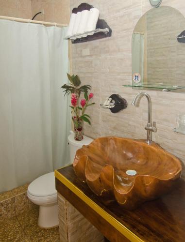 a bathroom with a wooden sink and a toilet at Deep Forest Garden Hotel in Puerto Princesa City