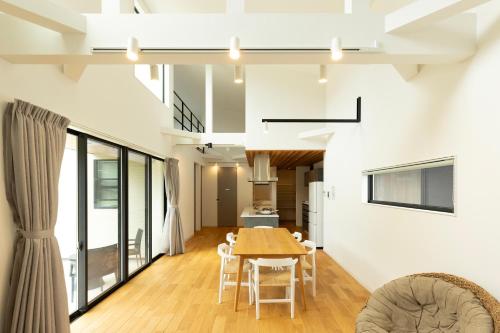 a dining room and kitchen with a table and chairs at 海沿いの1日1組限定の貸切別荘 Smile Itoshima Stay in Itoshima