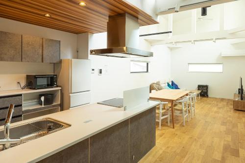 a kitchen with a table and a laptop on a counter at 海沿いの1日1組限定の貸切別荘 Smile Itoshima Stay in Itoshima