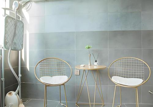 two chairs and a table in a bathroom at Borrman Hotel Zhenjiang Dashikou Suning Plaza in Zhenjiang