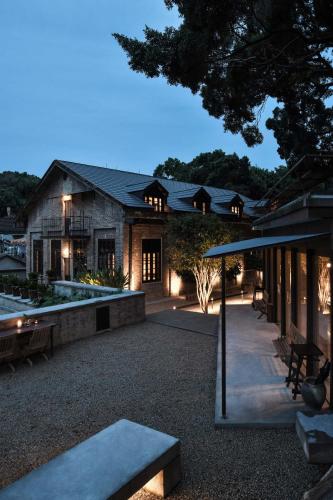 a house with a patio and a building at Gulangyu HUMBLE HALL Resort Hotel - Century-Old Historic Building & Banyan Courtyard - Near Sunlight Rock - Free Handmade Afternoon Tea & Breakfast - Pier Luggage Service - Free Island Walking guide & Hidden Route Guide - Paid English Tour Guide Service in Xiamen