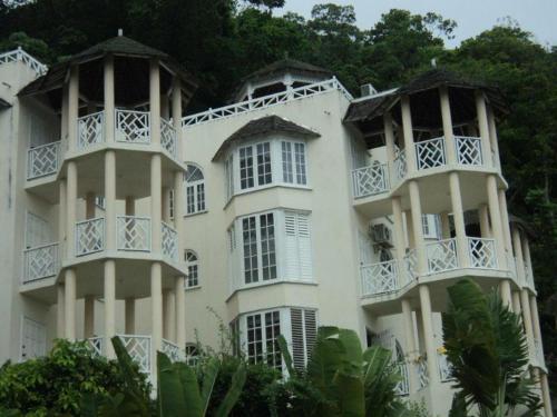 a large white building with white windows and trees at Chill on the Hill in Ocho Rios