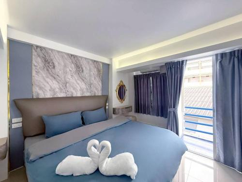 two white swans sitting on top of a blue bed at say hi pattaya hotel in Pattaya