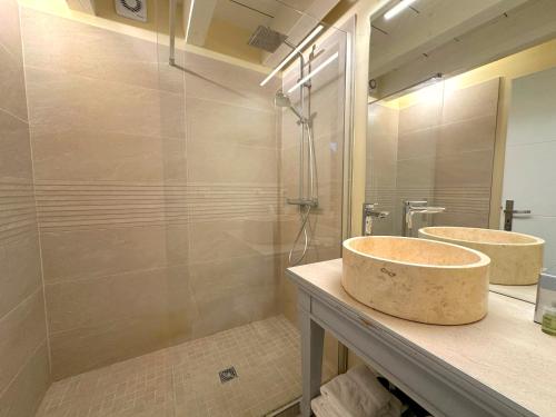 Un baño con dos lavabos y una ducha. en Clos de Fougères - Domaine intégral, en Montoillot