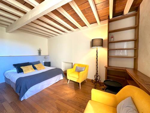 Un dormitorio con una cama y una silla amarilla. en Clos de Fougères - Domaine intégral, en Montoillot