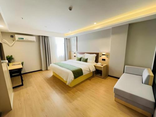 a hotel room with a bed and a couch at GreenTree Inn Anhui Suzhou Baima Mall Express Hotel in Suzhou