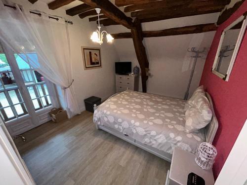 a bedroom with a bed and a large window at La Gentilhommière in Rogerville