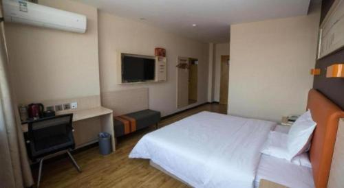 a bedroom with a white bed and a desk and a television at 7 Days Premium Yantai Zhaoyuan Leather Market in Zhaoyuan