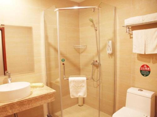 a bathroom with a shower and a toilet and a sink at GreenTree Alliance Yichang East Yichang Station Hotel in Yichang